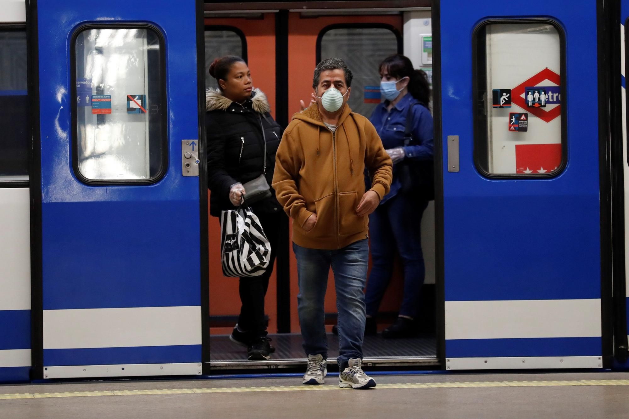 Varias personas con mascarilla en el metro de Madrid.