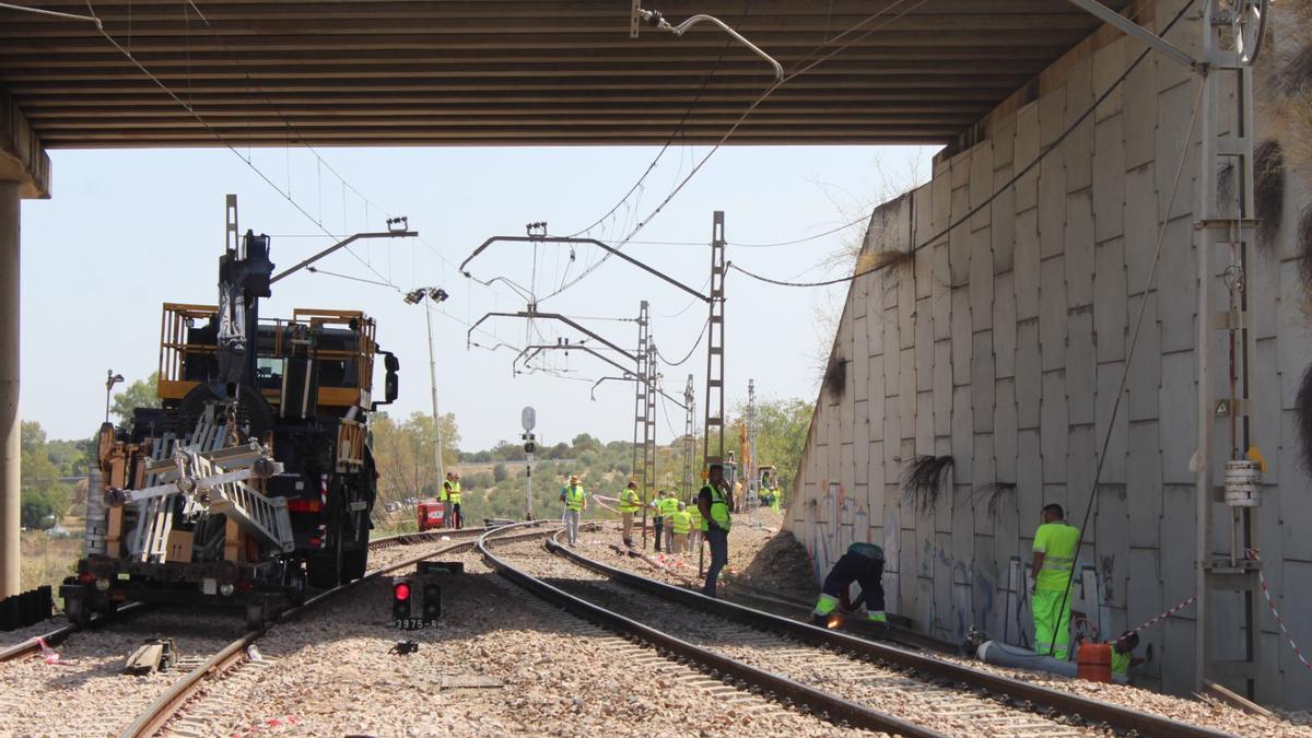 Técnicos y operarios trabajan en la reparación de la infraestructura ferroviaria dañada.