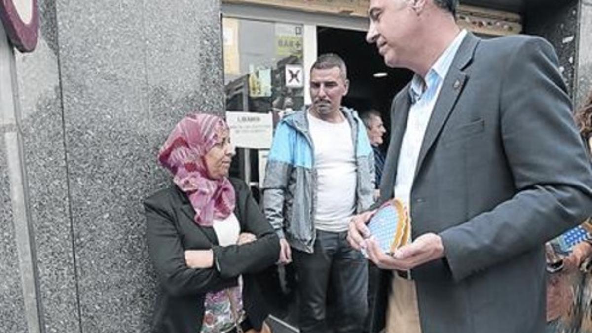 García Albiol mira a una mujer musulmana durante su visita al barrio del Fondo, en Santa Coloma, en abril.