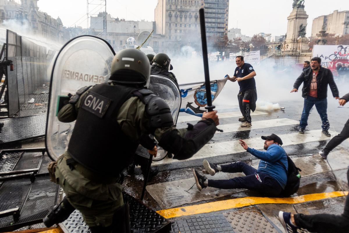 Manifestantes chocan con la policía antidisturbios frente al Congreso Nacional en Buenos Aires el 12 de junio de 2024. Los senadores argentinos debaten un paquete de reformas clave para el presidente ultraderechista Javier Milei, en una sesión marcada por huelgas y manifestaciones frente al Congreso.