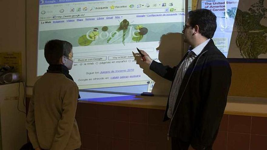 El profesor de Informática del IES Mare Nostrum con uno de los alumnos ante la pizarra digital casera con el bolígrafo infrarrojos