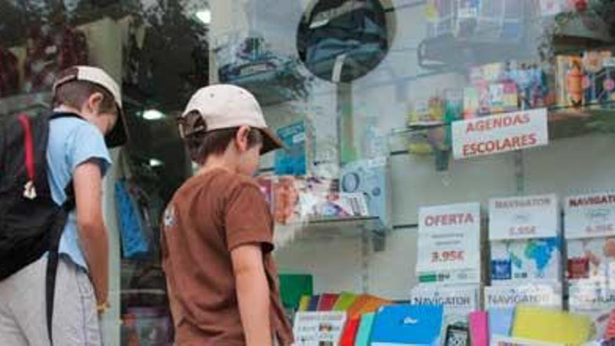 Dos niños ante un escaparate con material escolar.