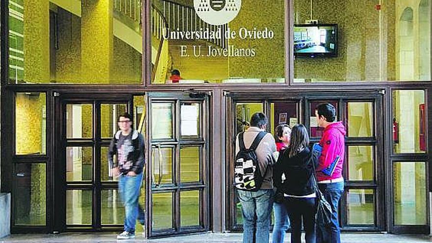 Un grupo de jóvenes, a las puertas de la Facultad de Ciencias Sociales de la Laboral, todavía rotulada como Escuela Jovellanos.