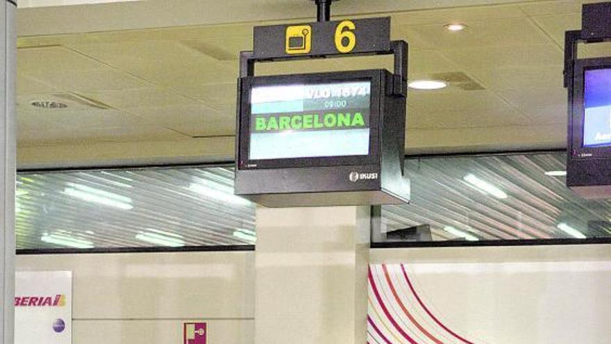 Tres viajeras, en uno de los mostradores de embarque para el servicio de Vueling a Barcelona de primera hora.