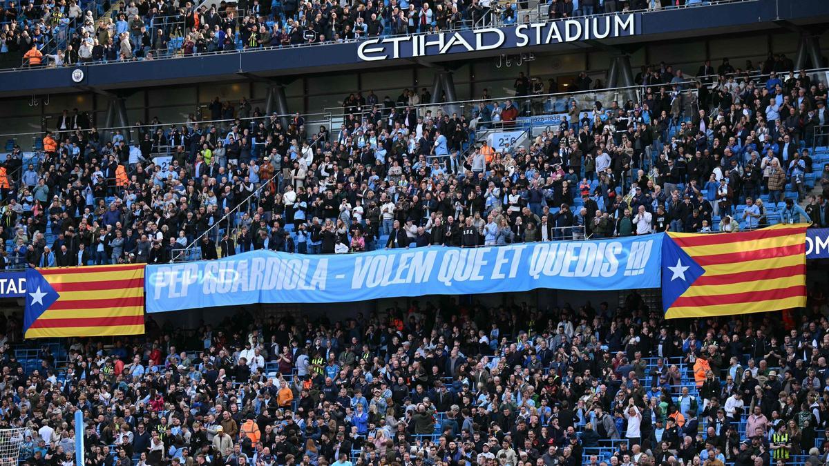 La afición del City pide a Guardiola con una pancarta, y en catalán, que no se vaya de Manchester.