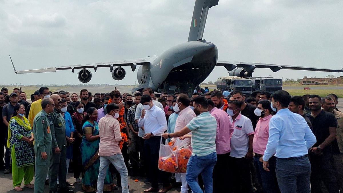 Los funcionarios de la misión india en Afganistán y los civiles indios evacuados aparecen en la fotografía después de que su vuelo aterrizara en la ciudad de Jamnagar, en el oeste de India.