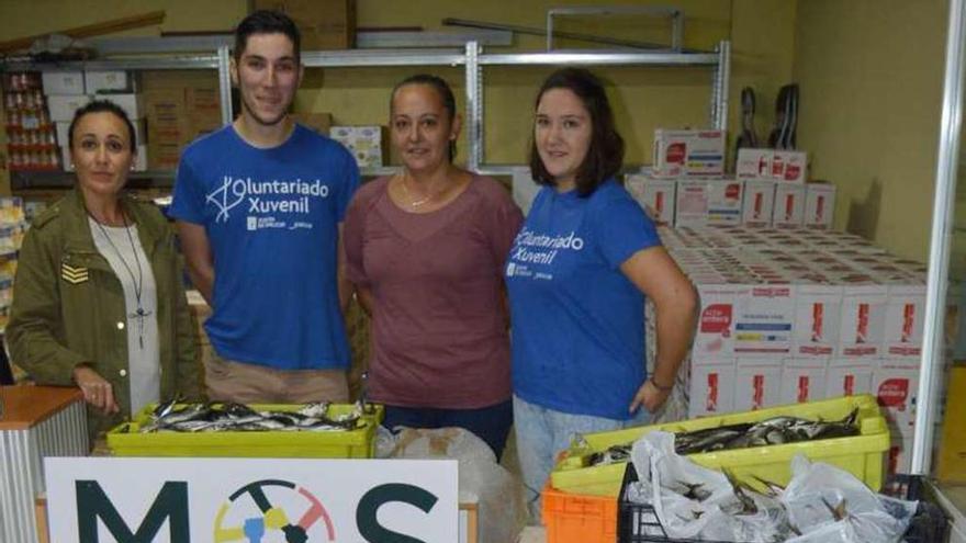 Sara Cebreiro (i.) con voluntarios en el local de &quot;Mos Axuda&quot;. // D.P.