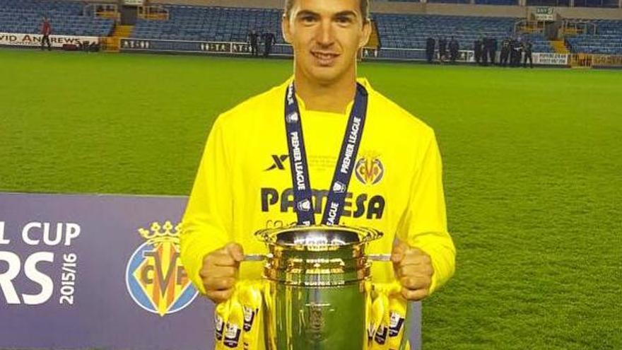 Carlitos muestra la copa de campeón