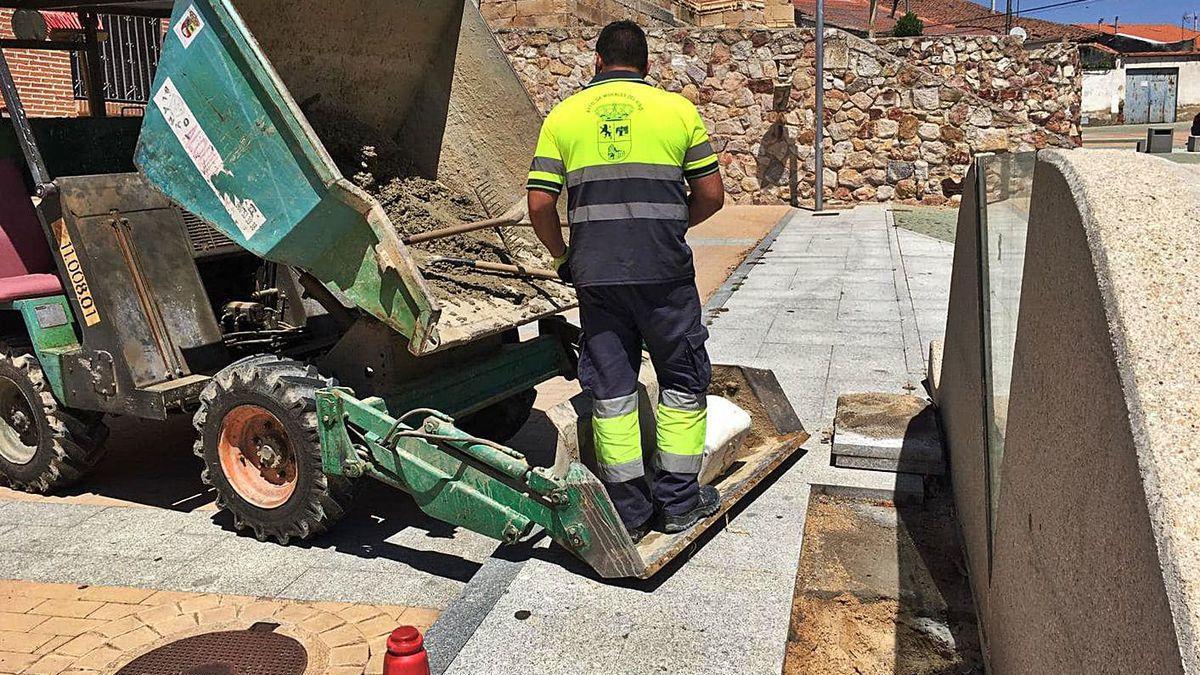 Un operario municipal coloca baldosas en la vía pública en Morales del Vino.