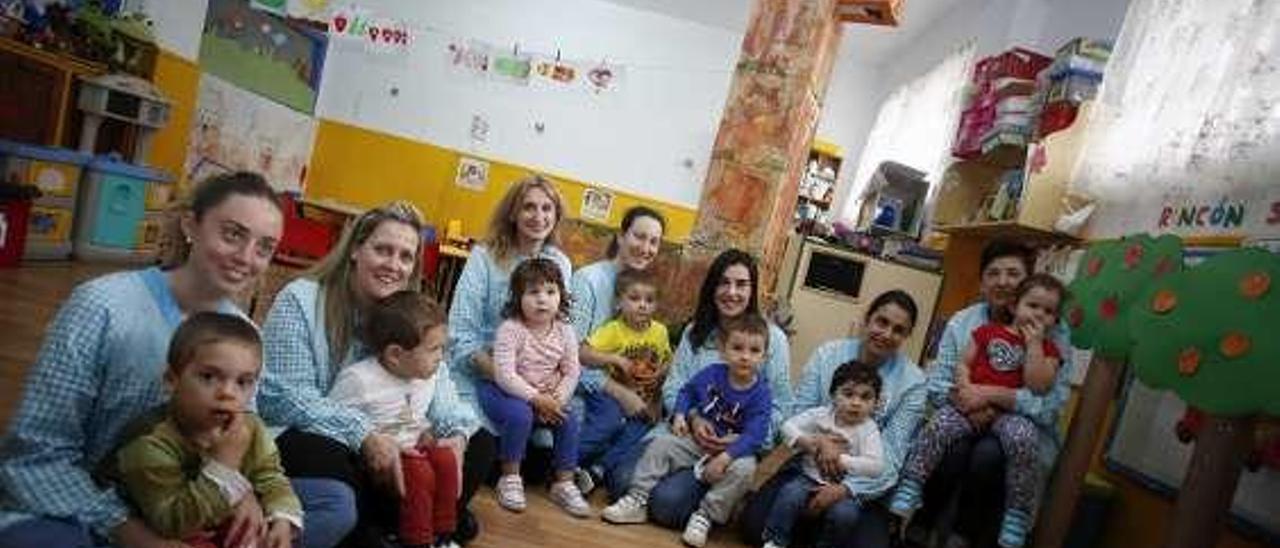 Los alumnos del colegio de Educación Infantil Sagrada Familia y sus educadoras, junto a una jirafa y unos árboles de material reciclado.