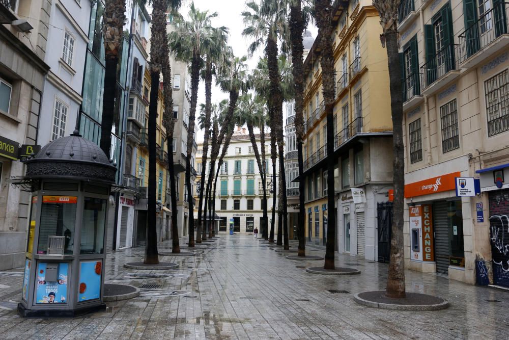 Pasan los días de confinamiento y la situación de la ciudad sigue siendo desértica. La siempre frecuentada calle Larios, la Alameda, principal vía de tráfico tanto privado como público del centro de la ciudad, y el bullicioso mercado de Atarazanas presentan durante el estado de alarma provocado por la pandemia de coronavirus una imagen inusual, acentuada por la persistente lluvia de esta semana.