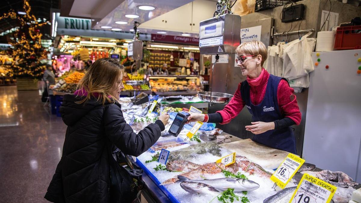 Elisenda Goñi, pescadera, cobra a una clienta.