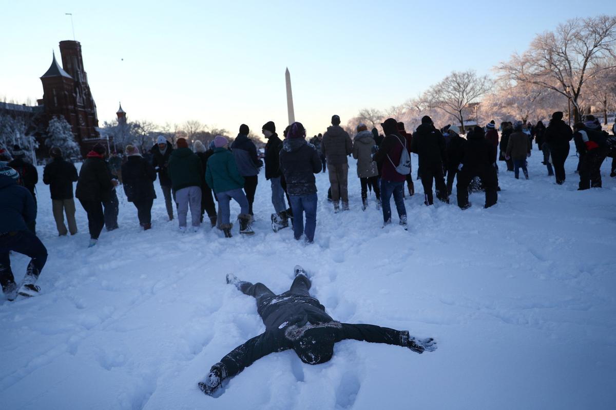 Una persona descansa en el suelo tras la pelea de bolas de nieve, Batalla de Snomicron, cerca del Capitolio de EE. UU..