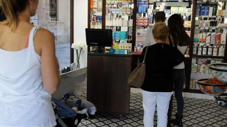 Varios clientes en una farmacia de la capital.