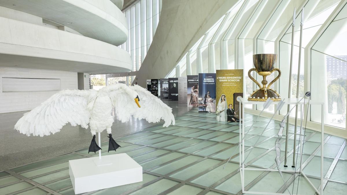 Piezas que se iban a subastar de la ópera Parsifal donadas a València para el museo del Santo Cáliz con los carteles al fondo de otras producciones del coliseo