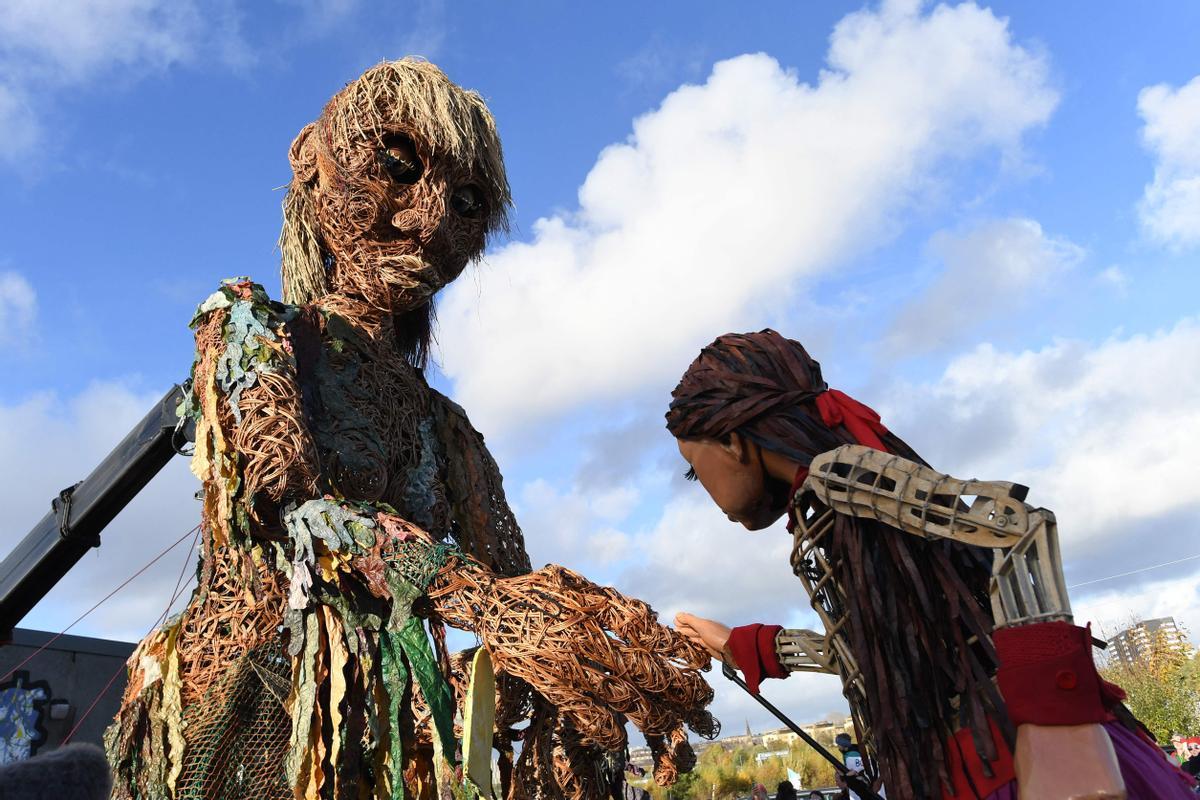 Storm, una marioneta de 10 metros de altura, representando la diosa del mar para concienciar de los océanos en crisis, se encuentra con Little Amal, en Govan, Glasgow, el 10 de noviembre de 2021.