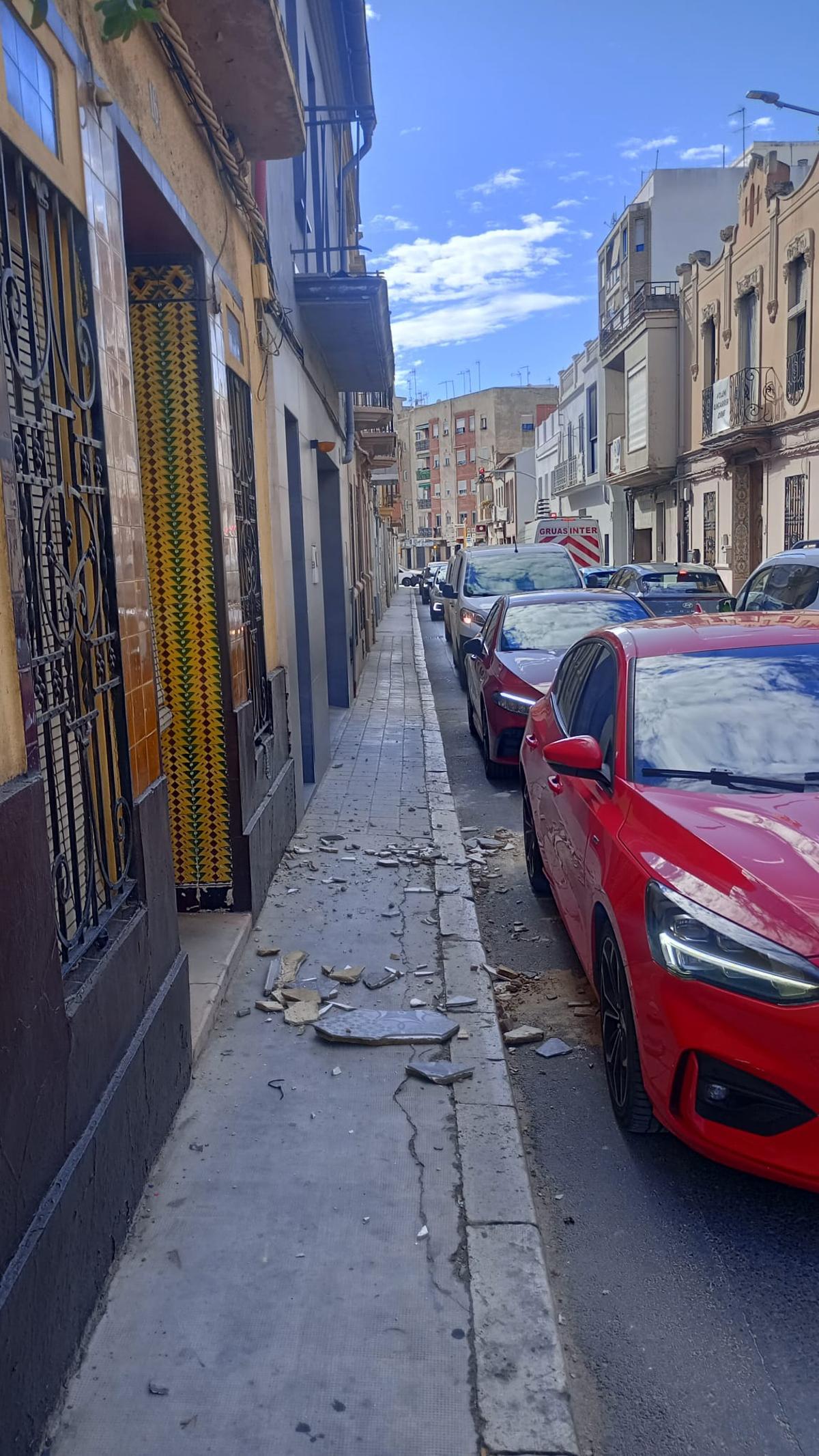 Cascotes en la calle Rafael Valls tras destrozarse un balcón.
