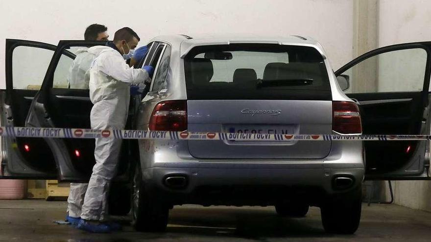 Agentes inspeccionan el vehículo en el que fue hallado el cadáver de la fallecida.