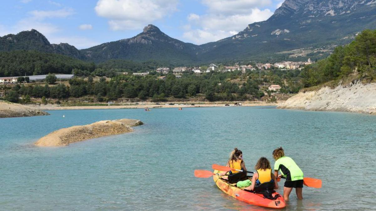 Un caiac al pantà de la Llosa del Cavall amb Sant Llorenç de fons