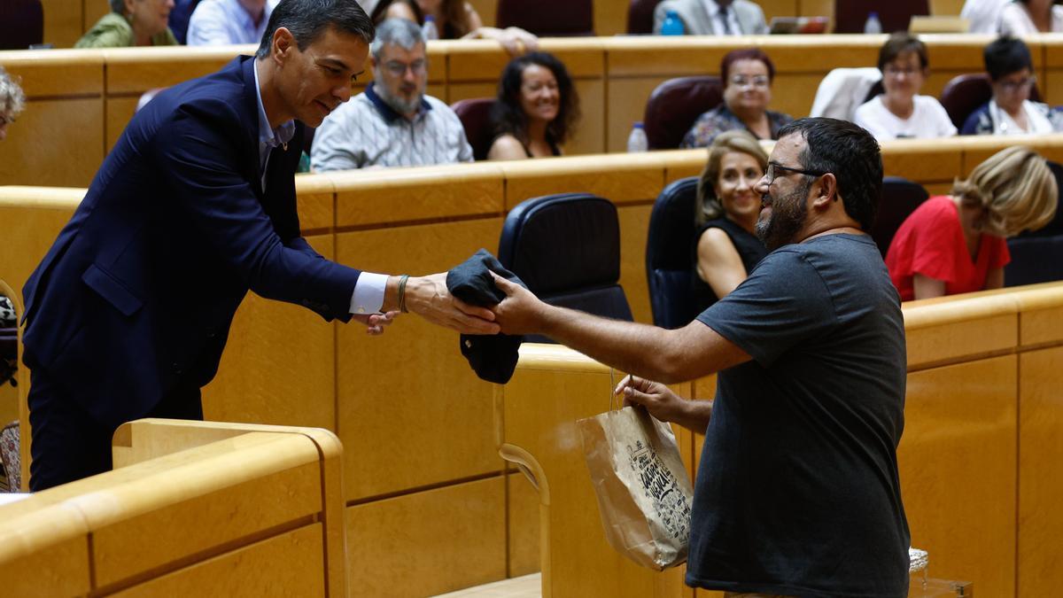 Vicenç Vidal, senador de Més per Mallorca, le entrega una camiseta de Melicotó al presidente del Gobierno en el Senado.