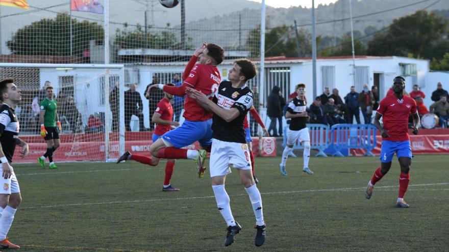 El roget Pedro Torres i el blanc-i-vermell Marc Cuello lluiten per una pilota aèria mentre Jaume Pascual i Sana Ndiaye els observen