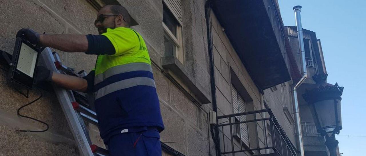 Operario, ayer, instalando uno de los focos con una farola fernandina al lado. |  FDV