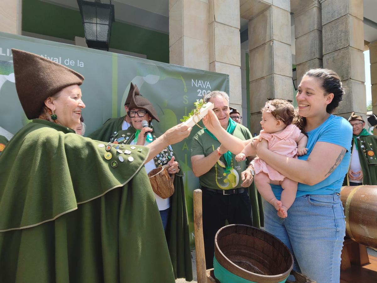 El bautismo sidrero de una veintena de bebés en el Festival de la Sidra de Nava, en imágenes