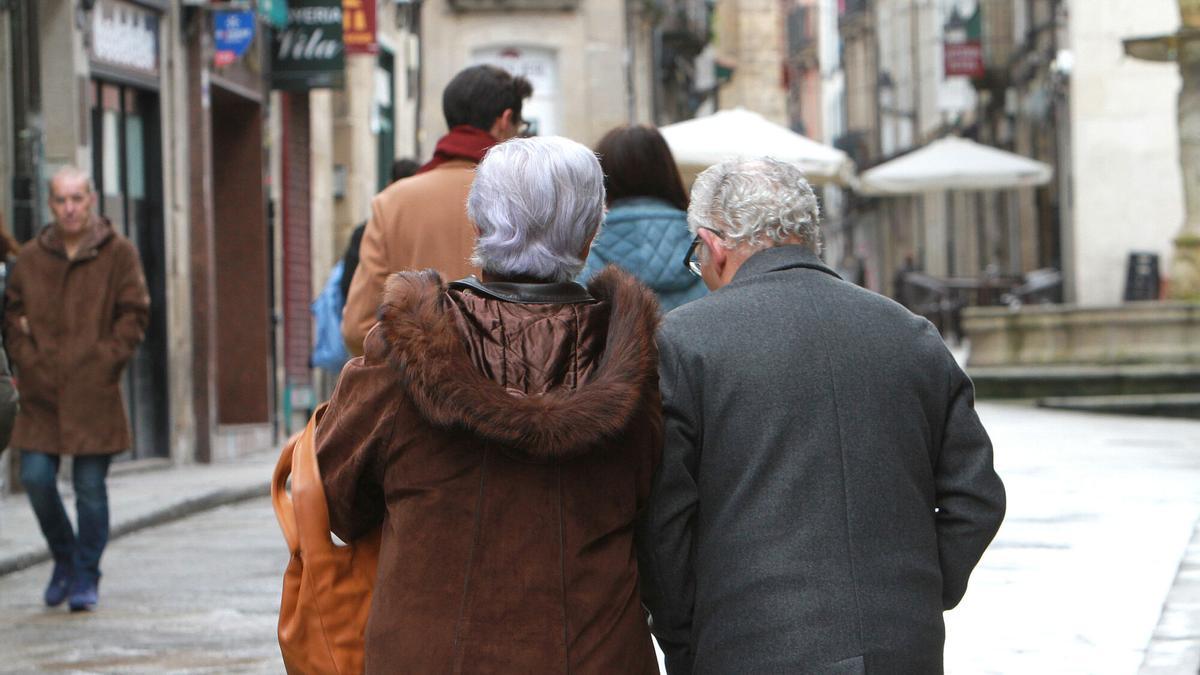 Pareja de pensionistas paseando por la calle.
