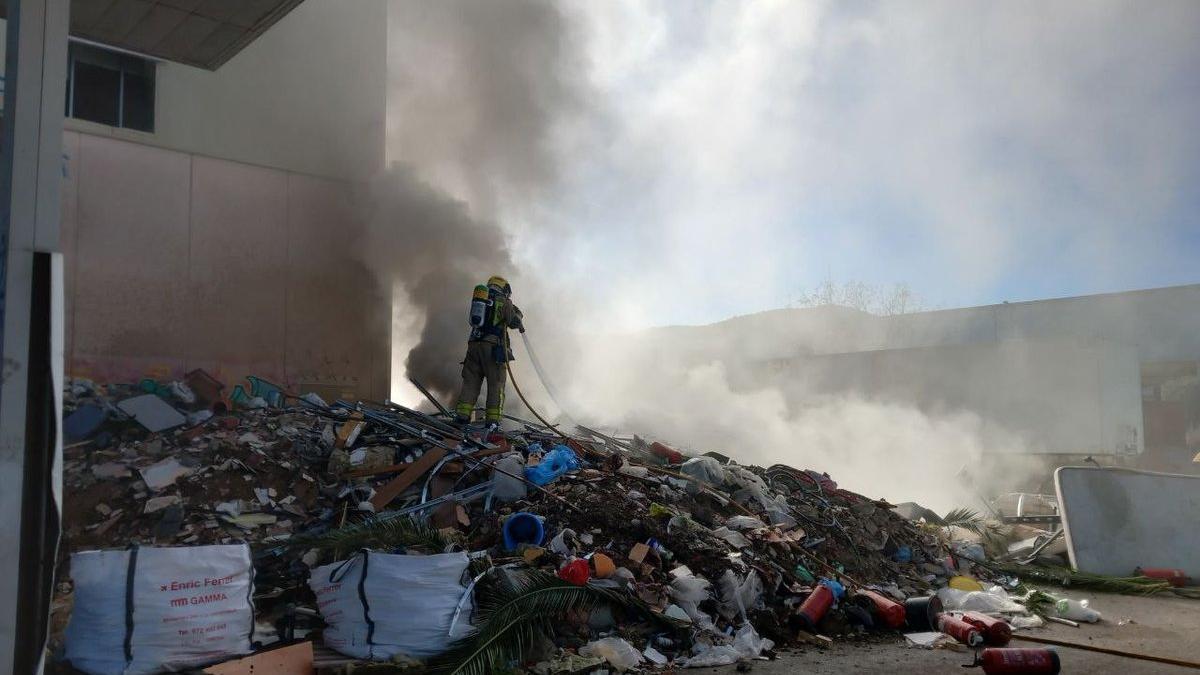 Els bombers treballant en l'extinció de l'incendi a Celrà