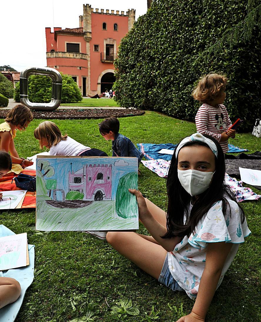 Una niña enseña su dibujo, con el edificio del museo al fondo. | Juan Plaza