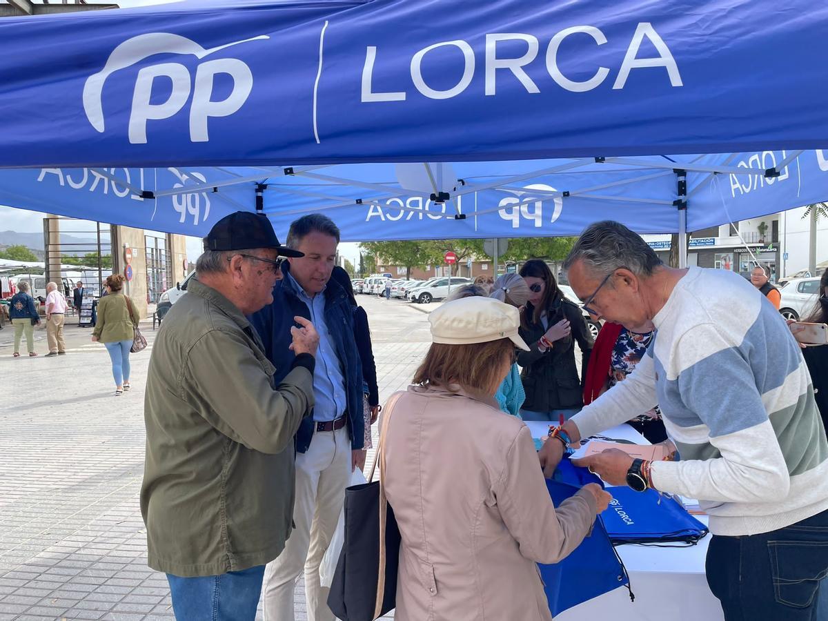 El candidato a la Alcaldía por el PP, Fulgencio Gil, tras realizar la compra en el mercado charlaba con los lorquinos que se acercaban hasta la carpa de los populares.
