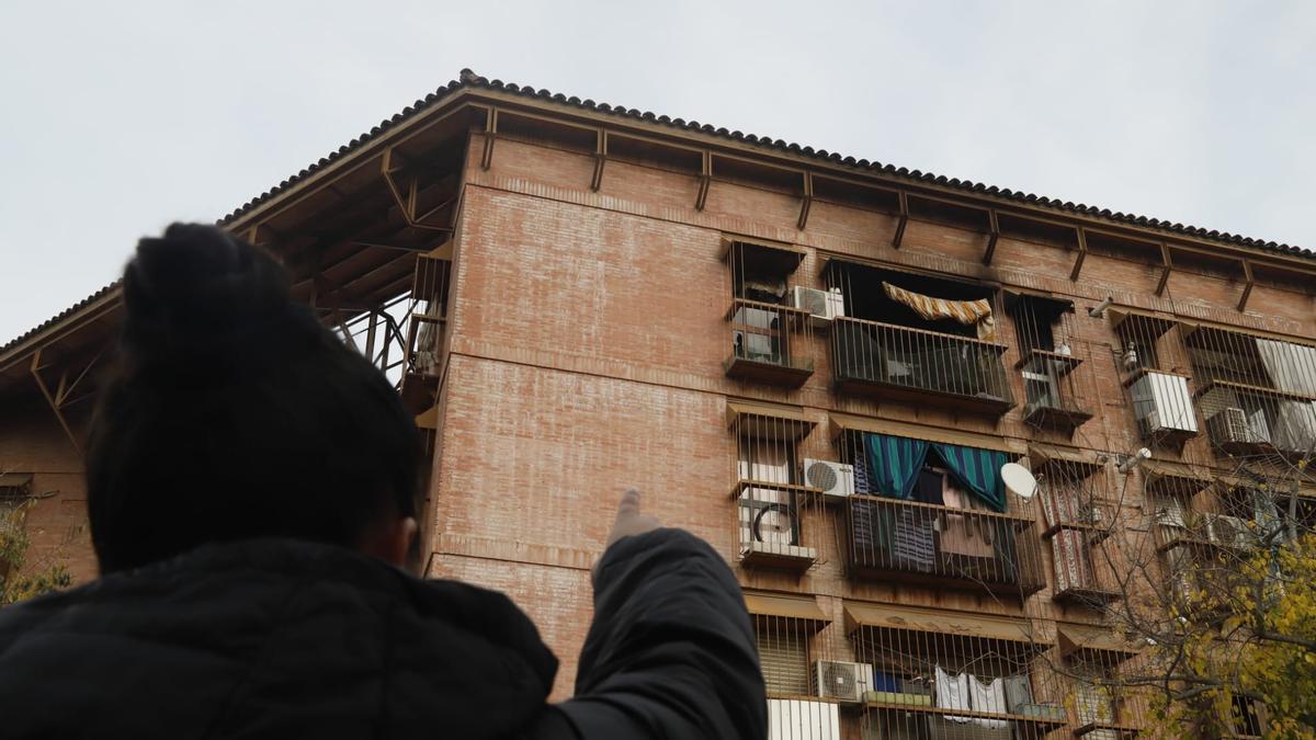 Un vecino del barrio de las Moreras señala el balcón de la vivienda donde se ha registrado el incendio en el que han muerto una abuela y su nieta.