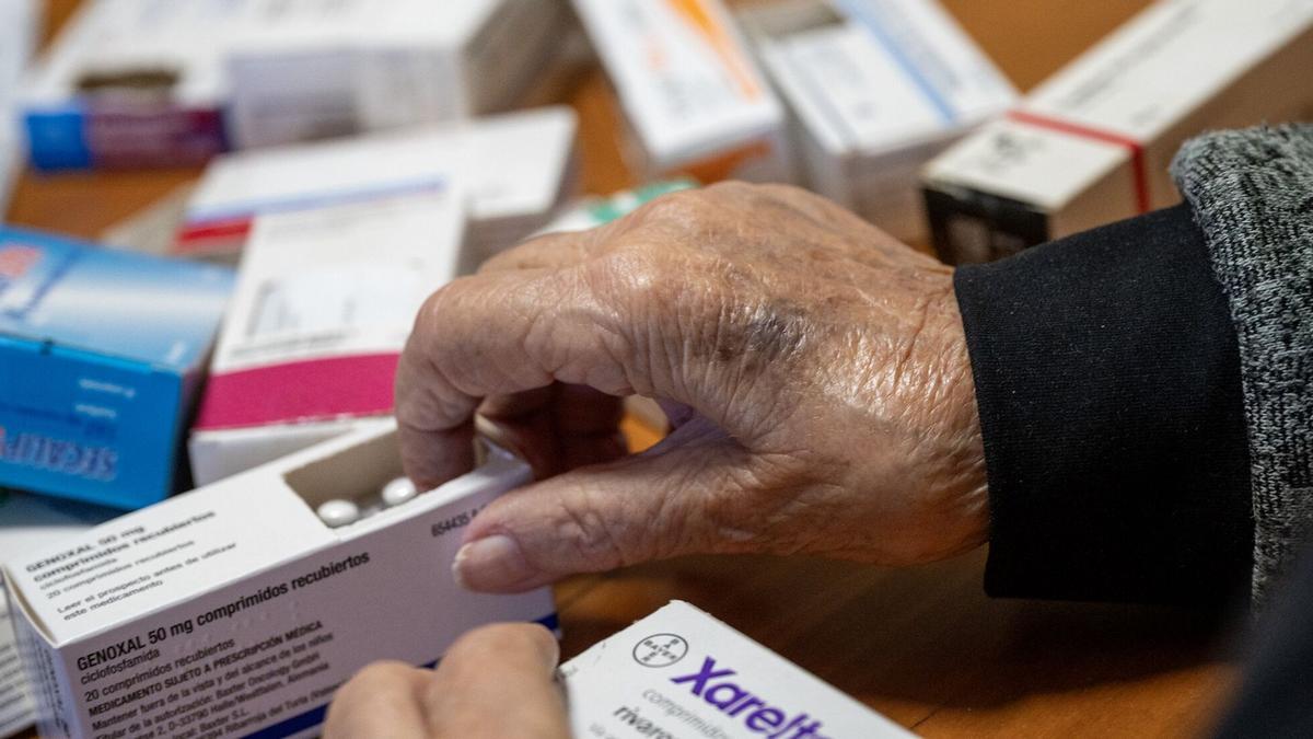 Una persona de avanzada edad manipula unos medicamentos.