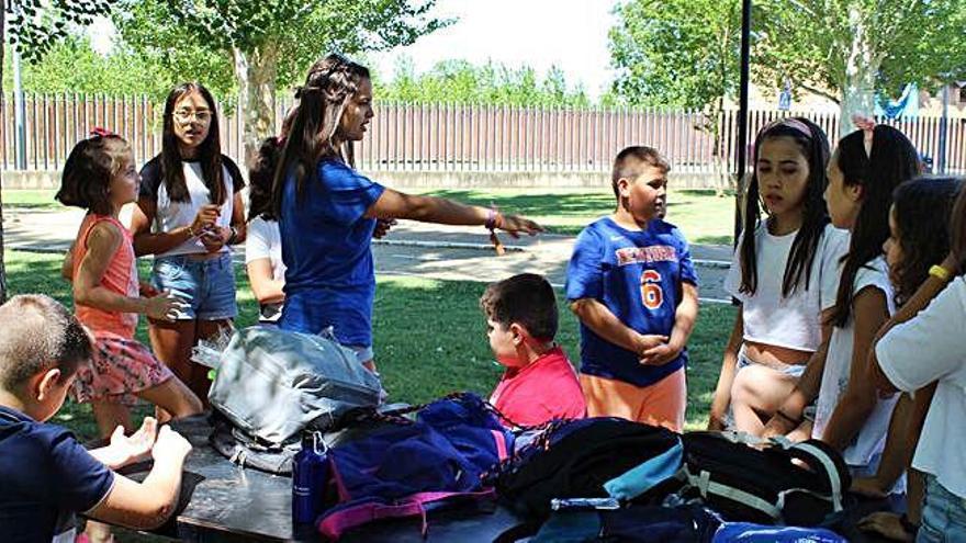 Una de las monitoras explica una actividad a los niños participantes del campamento urbano.