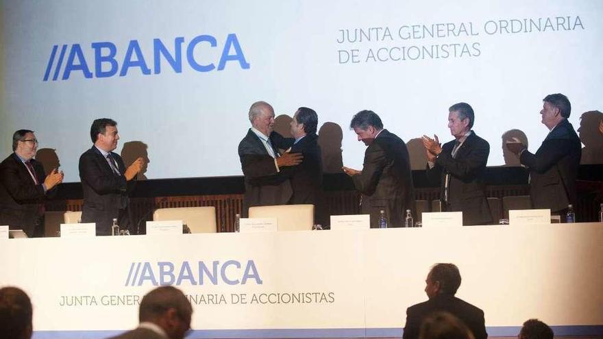 Javier Etcheverría se abraza a Juan Carlos Escotet ante el consejo con Francisco Botas (izda.). // C.R.