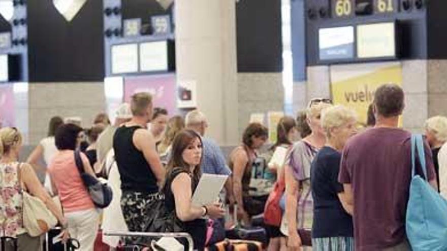 Pasajeros hacen cola para facturar en el aeropuerto de Palma.