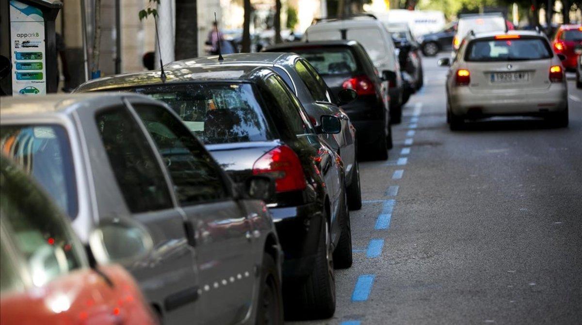 Varios coches estacionados en la zona azul de Barcelona. 