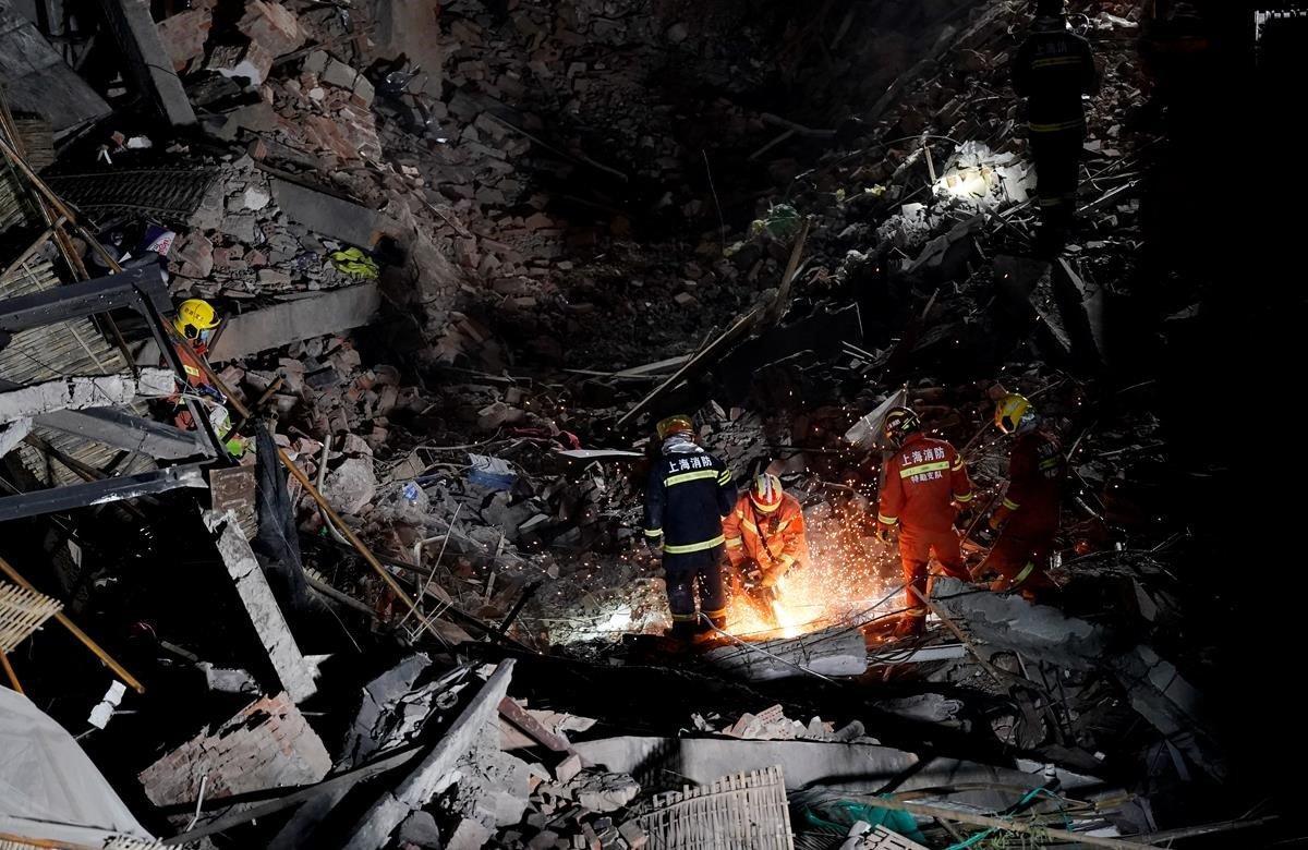 El derrumbe de un edificio en el centro de la ciudad china de Shanghái dejó un saldo de 10 personas muertas y 15 rescatadas, informaron el viernes autoridades locales. En la imagen los bomberos buscando a posibles víctimas.