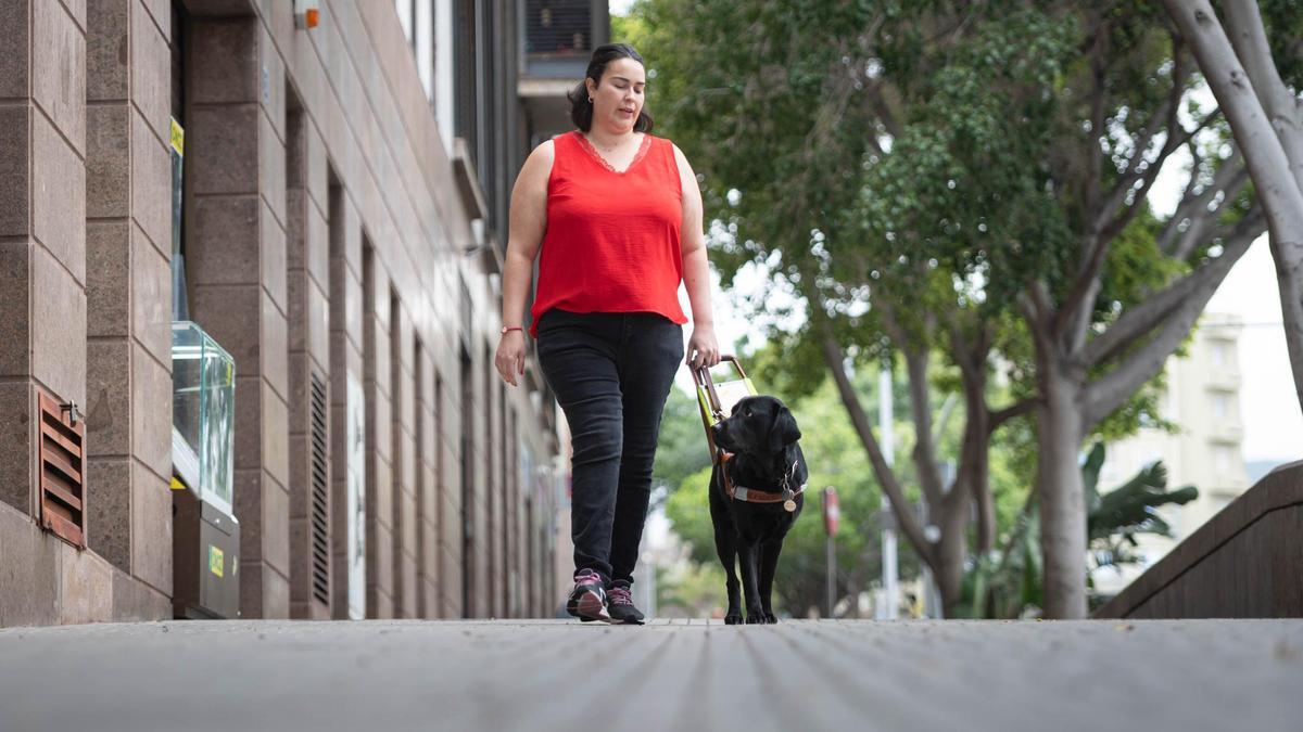 Yasmina García junto a Kina, su perro de asistencia, en las inmedicaciones de la ONCE