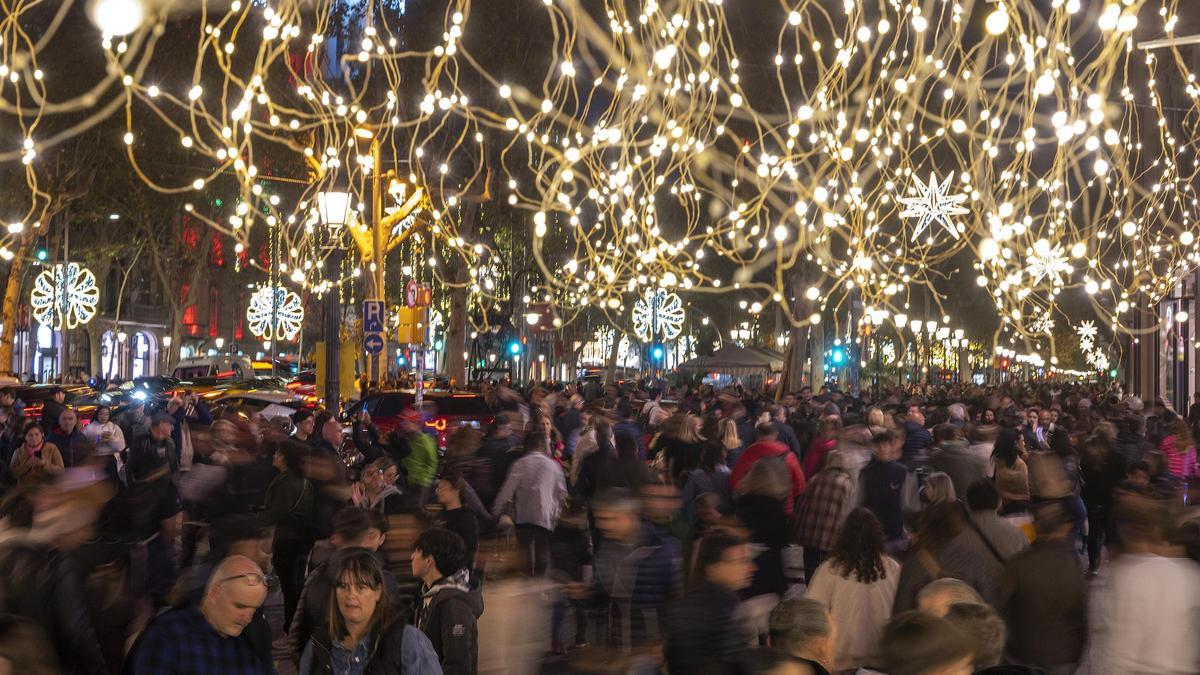 El centro de Barcelona abarrotado de gente bajo las luces de decoración de la Navidad.
