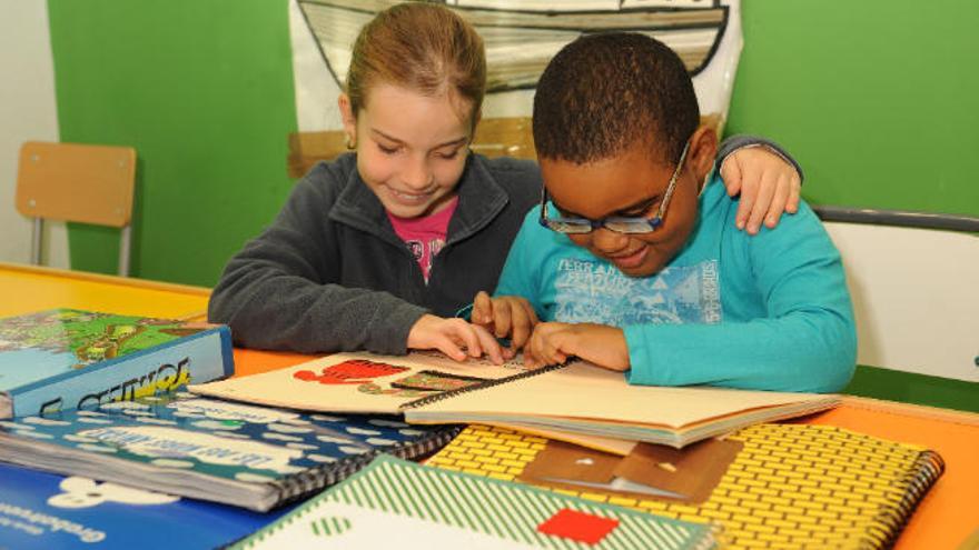 Dos alumnos practican la lectura en braille.