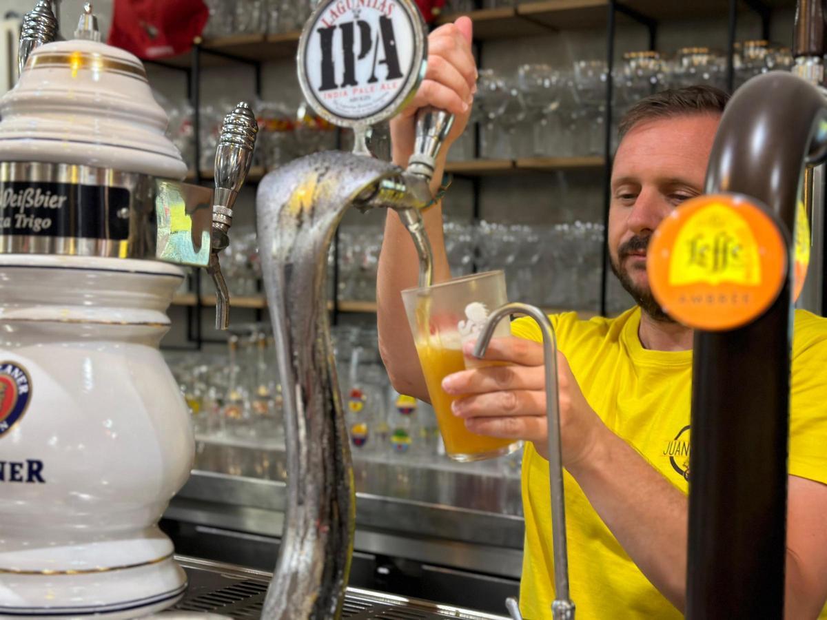 Alejandro Carranza, copropietario del negocio, sirviendo una cerveza en el Bar Juan Carlos.