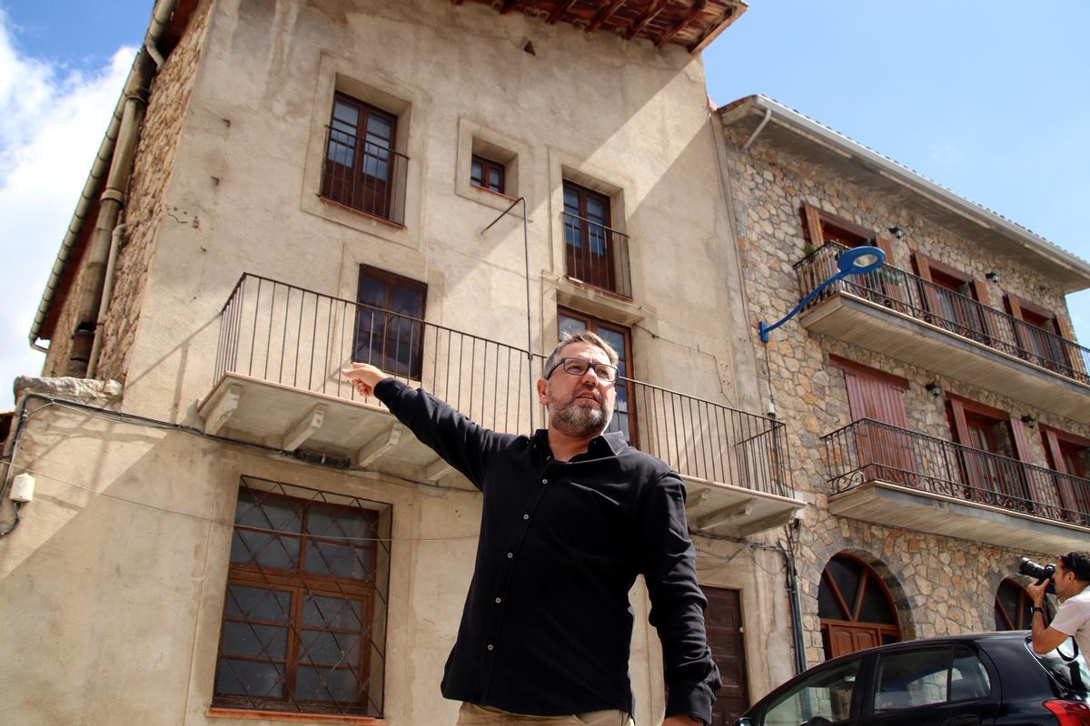 Iñaki Rubio, este jueves en Gósol, señalando el balcón (arriba a la izquierda) de la habitación en que se alojó en 1906 en Cal Tampanada.