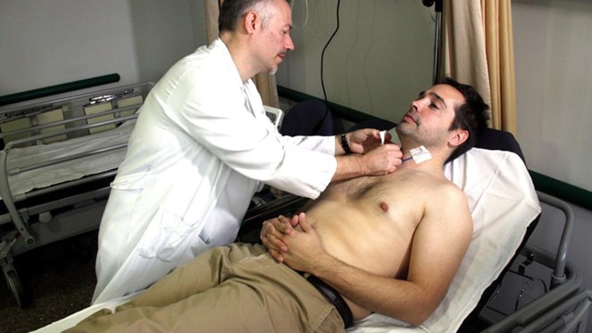 Un médico coloca sobre el paciente los sensores para hacer el análisis de sangre no invasivo.
