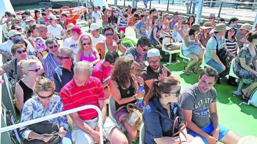 Pasajeros a bordo del catamarán atracado en el embarcadero de A Laxe ante de salir rumbo Cíes.