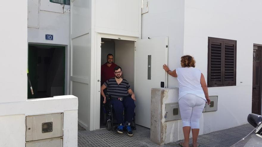 Tana Hernández, en la silla de ruedas, y su hermano, Pedro, este domingo salen a la calle desde el elevador instalado junto a su casa en Valterra.