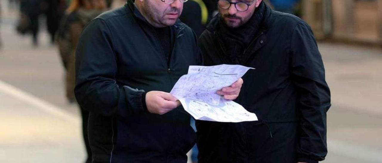 Dos turistas consultaban un mapa ayer en el centro de Pontevedra. // Rafa Vázquez