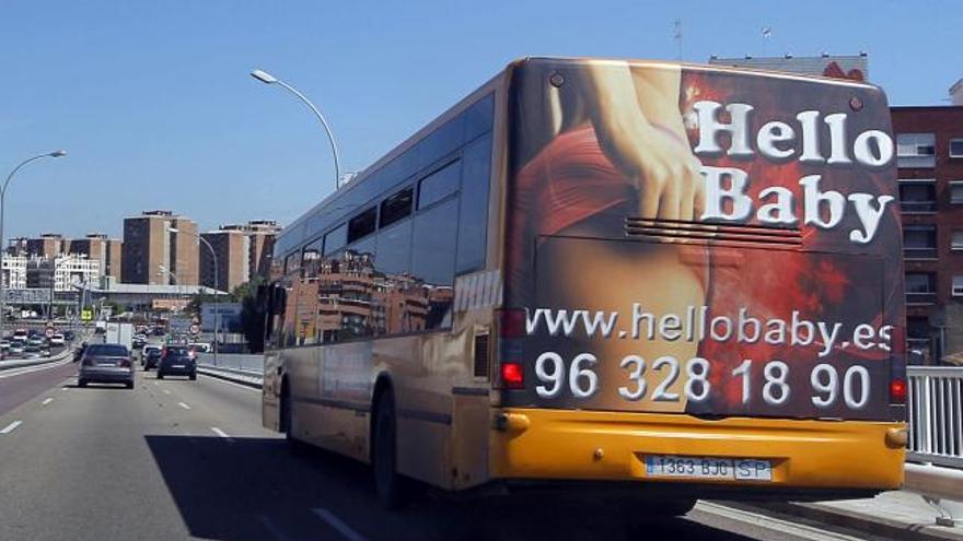 Uno de los autobuses de la Entidad de Transporte Metropolitano de Valencia que luce publicidad de una página de contactos circulando por el acceso sur de la ciudad.