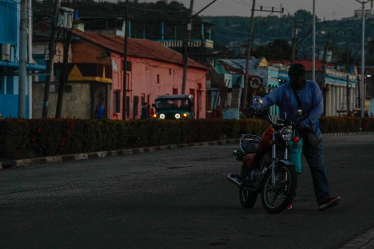 Un hombre empuja una motocicleta durante un apagón en Santiago de Cuba, el 14 de mayo de 2026. El gobierno cubano atribuyó a Estados Unidos la situación “particularmente tensa” de su red eléctrica, mientras el este del país sufrió otro corte generalizado ese mismo día. Washington ha ofrecido nuevamente 100 millones de dólares en ayuda, que el gobierno de la isla se muestra “dispuesto” a considerar.