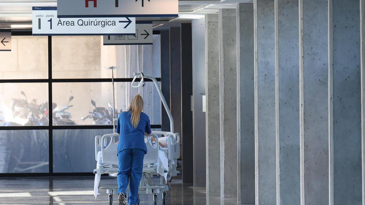 Una sanitaria empuja una camilla en el Hospital Can Misses.